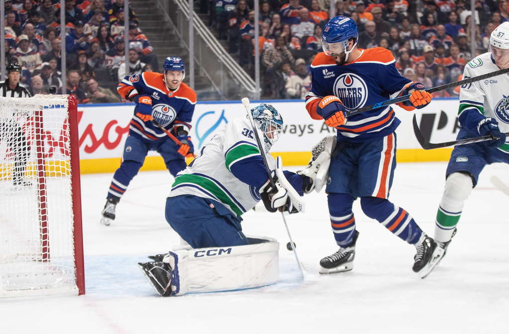 Vancouver Canucks goalie Thatcher Demko (35) makes the save against Edmonton Oilers' Adam Henrique (19) during the second period of an NHL hockey game in Edmonton, Alberta, Saturday, Oct. 11, 2025. (Jason Franson/The Canadian Press via AP)