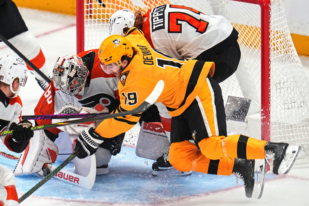Philadelphia Flyers goaltender Dan Vladar (80) blocks shot with teammate Owen Tippett (74) defending against Pittsburgh Penguins' Connor Dewar (19) during the first period of Game 5 in the first round of an NHL hockey Stanley Cup playoff series in Pittsburgh, Monday, April 27, 2026. (AP Photo/Gene J. Puskar)
