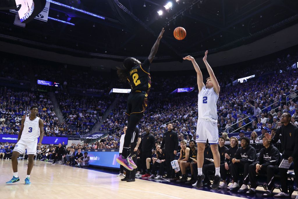 BYU forward Tyler Mrus (2) shoots a three point basket over Arizona State guard Anthony Johnson (2) during the first half of an NCAA basketball game, Wednesday, Jan. 7, 2026, in Provo, Utah. (AP Photo/Rob Gray)