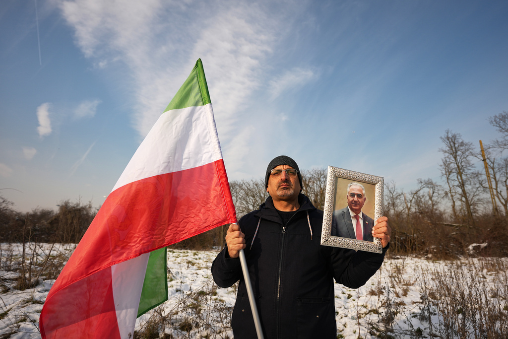 A member of the Iranian community holds a photograph of Iran's exiled crown prince Reza Pahlavi outside the U.S. embassy in Bucharest, Romania, Wednesday, Jan. 14, 2026, during a rally in support of anti-government protests in Iran. (AP Photo/Andreea Alexandru)