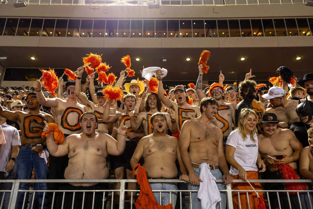 Oklahoma State fans cheer in Section 231 in the first half of an NCAA college football game against Cincinnati, Saturday, Oct. 18, 2025, in Stillwater, Okla. (AP Photo/Mitch Alcala)