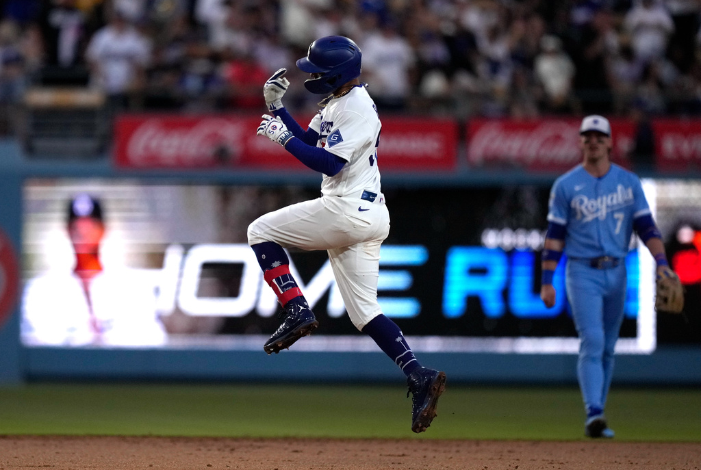 Los Angeles Dodgers' Mookie Betts, left, celebrates after hitting a solo home run as Kansas City Royals shortstop Bobby Witt Jr. watches during the second inning of a baseball game Wednesday, Aug. 12, 2026, in Los Angeles. (AP Photo/Mark J. Terrill)