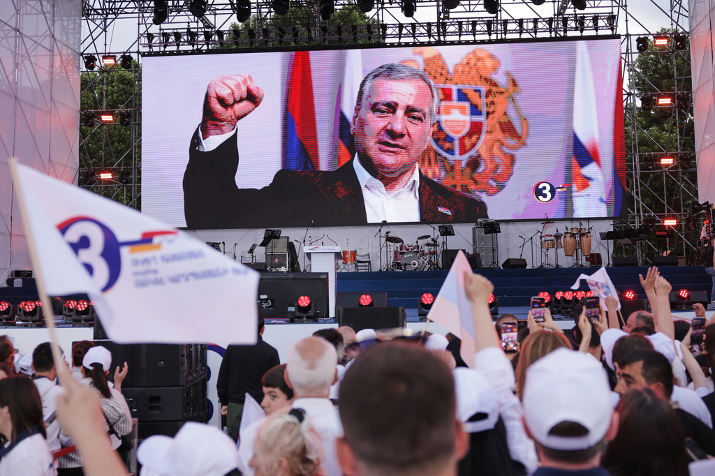 Supporters of Russian-Armenian tycoon Samvel Karapetyan, on screen, attend a rally against incumbent Prime Minister Nikol Pashinyan at Republic Square in Yerevan, Armenia, Wednesday, June 3, 2026. (AP Photo/Anthony Pizzoferrato)
