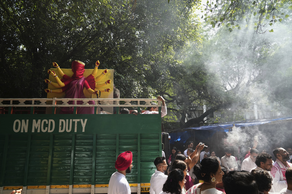 Devotees sing and dance as they transport an idol of the Hindu goddess Durga to their place of worship ahead of the Durga Puja festival in New Delhi, India, Sunday, Sept. 21, 2025. (AP Photo/Manish Swarup)