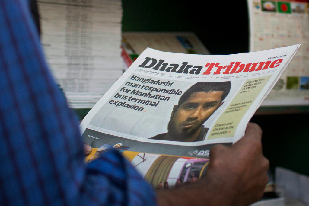 FILE - A man reads a national newspaper whose front page shows the news of Bangladeshi man Akayed Ullah, Dec. 12, 2017 in Dhaka, Bangladesh. (AP Photo/A.M. Ahad, File)