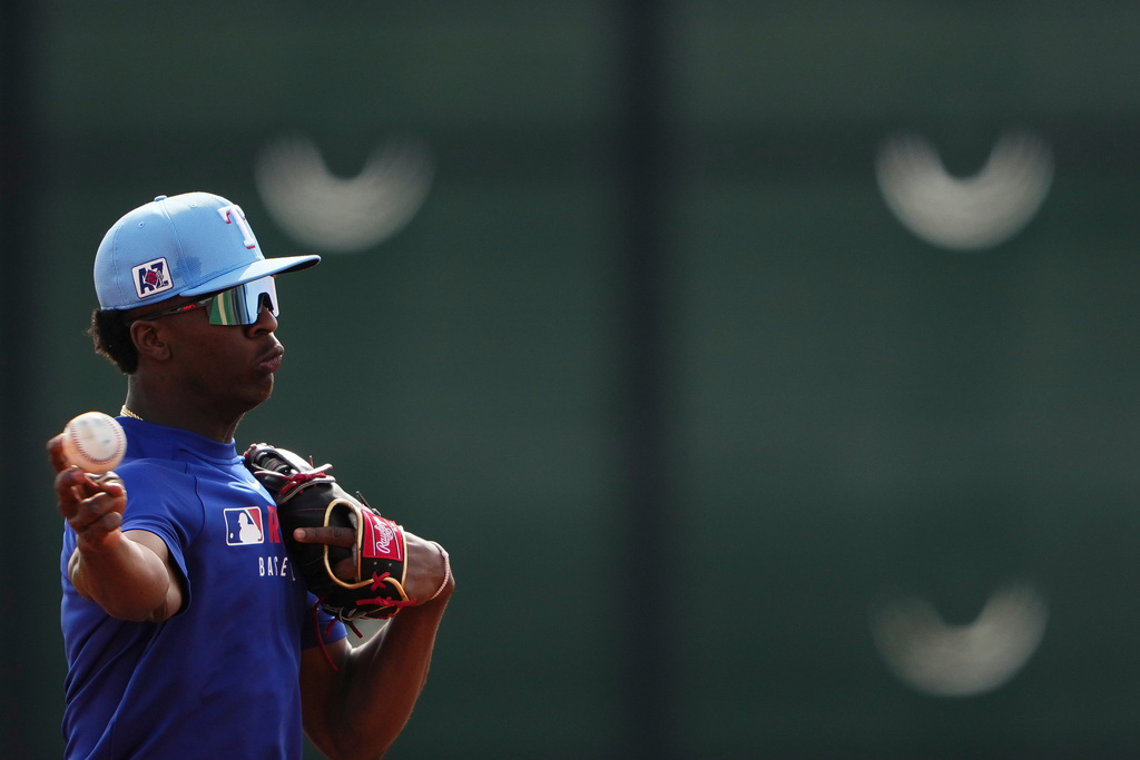 FILE - Texas Rangers infielder Sebastian Walcott throws while running fielding drills during spring training baseball practice at the team's training facility Feb. 17, 2025, in Surprise, Ariz. (AP Photo/Lindsey Wasson, File)