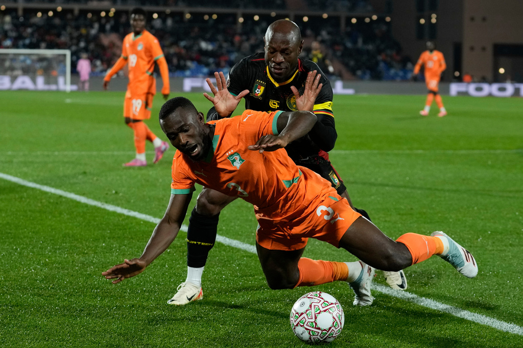 Ivory Coast's Ghislain Konan is challenged by Cameroon's Christian Bassogog during the Africa Cup of Nations group F soccer match between Ivory Coast and Cameroon, in Marrakech, Morocco, Sunday, Dec. 28, 2025. (AP Photo/Themba Hadebe)