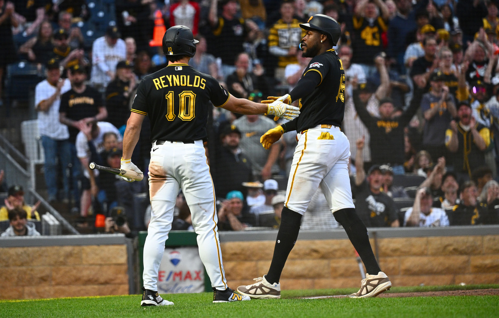 Pittsburgh Pirates' Oneil Cruz, left, celebrates with Bryan Reynolds after scoring on a single by Brandon Lowe during the fifth inning of a baseball game against the Colorado Rockies in Pittsburgh, Tuesday, May 12, 2026. (AP Photo/Justin Berl)