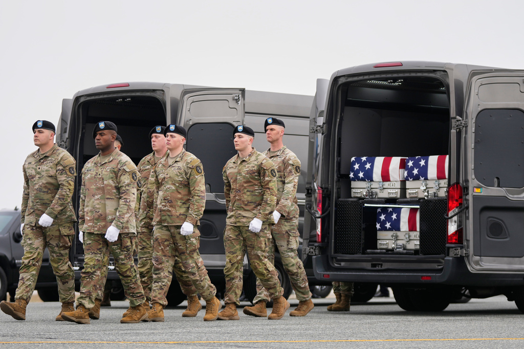 An Army carry team walk away from a transport van containing the remains of U.S. Army Reserve soldiers Maj. Jeffrey O'Brien, of Indianola, Iowa, Capt. Cody Khork, of Winter Haven, Fla., and Chief Warrant Officer 3 Robert Marzan, of Sacramento, Calif., who were killed in a drone strike at a command center in Kuwait after the U.S. and Israel launched its military campaign against Iran, during a casualty return, Saturday, March 7, 2026, at Dover Air Force Base, Del. (AP Photo/Mark Schiefelbein)