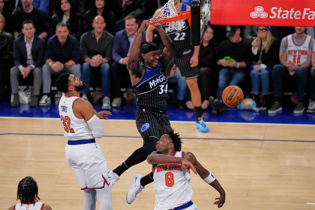 Orlando Magic's Wendell Carter Jr. (34) dunks the ball in front of New York Knicks' Karl-Anthony Towns (32) and Og Anunoby (8) during the second half of an NBA basketball game Wednesday, Nov. 12, 2025, in New York. (AP Photo/Frank Franklin II)
