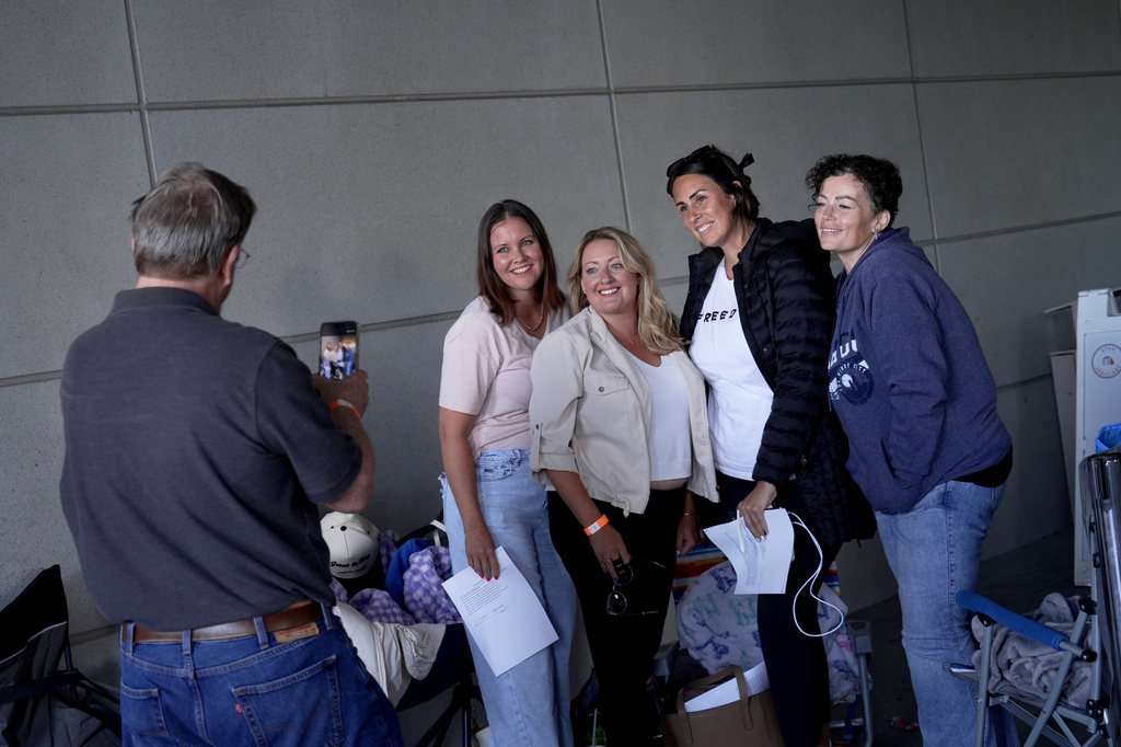 Courtroom spectators take a photo together after receiving wristbands for one of the few available public seats at a preliminary hearing for Tyler Robinson, the Utah man accused of fatally shooting Charlie Kirk, Tuesday, July 7, 2026, in Provo, Utah. (AP Photo/Ty ONeil)