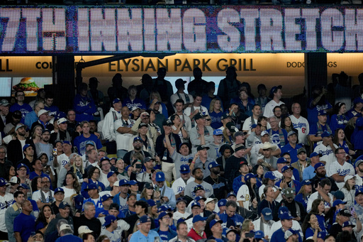 Fans stand during the 14th inning in Game 3 of baseball's World Series between the Los Angeles Dodgers and the Toronto Blue Jays, Monday, Oct. 27, 2025, in Los Angeles. (AP Photo/Ashley Landis) Fans stand during the 14th inning in Game 3 of baseball's World Series between the Los Angeles Dodgers and the Toronto Blue Jays, Monday, Oct. 27, 2025, in Los Angeles. (AP Photo/Ashley Landis)
