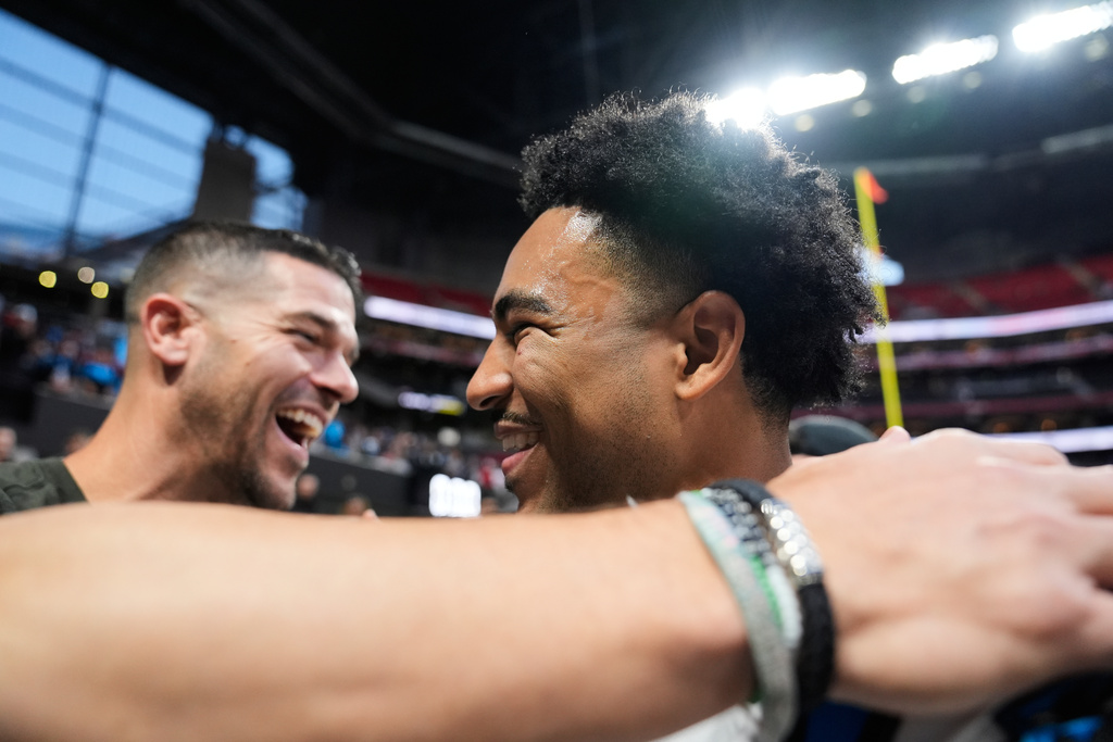 Carolina Panthers head coach Dave Canales, left, greets quarterback Bryce Young (9) celebrates after an overtime victory over the Atlanta Falcons in an NFL football game, Sunday, Nov. 16, 2025, in Atlanta. (AP Photo/Brynn Anderson)