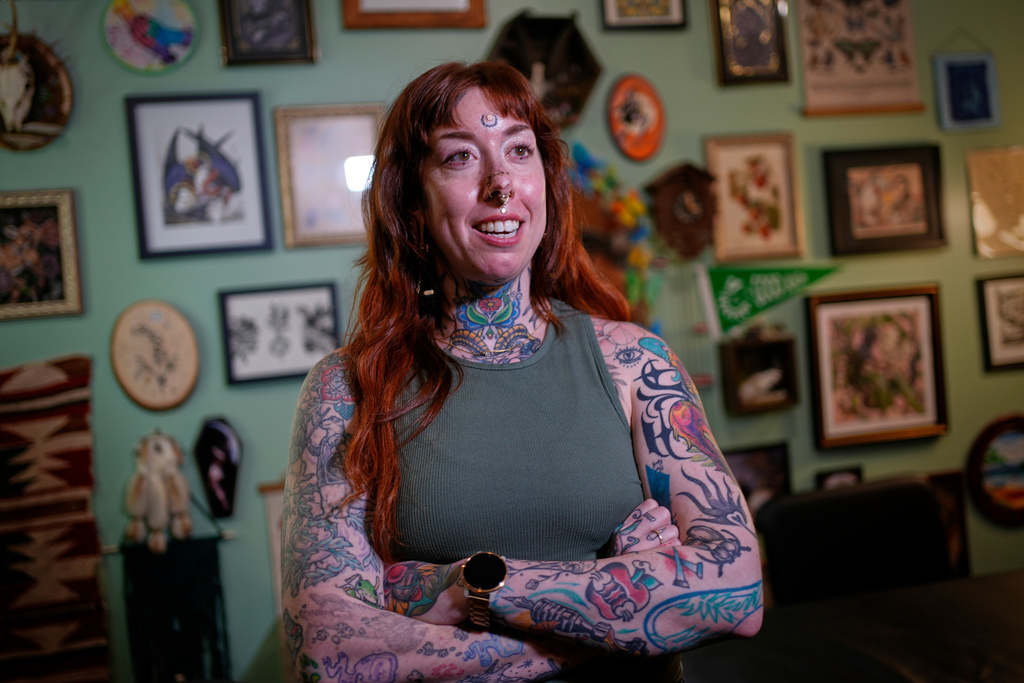 Tattoo artist Mischa Ostberg talks with a visitor at the Ghost Rose Tattoo parlor, Nov. 3, 2025, in Ellsworth, Maine. (AP Photo/Robert F. Bukaty)
