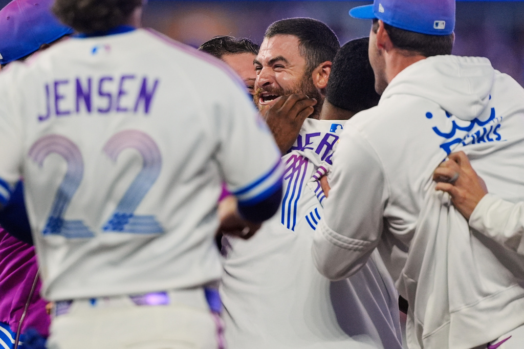 Kansas City Royals players celebrate after Kyle Isbel, center, hit a single to drive in the game-winning run during the ninth inning of a baseball game against the Detroit Tigers, Friday, May 8, 2026, in Kansas City, Mo. (AP Photo/Charlie Riedel)