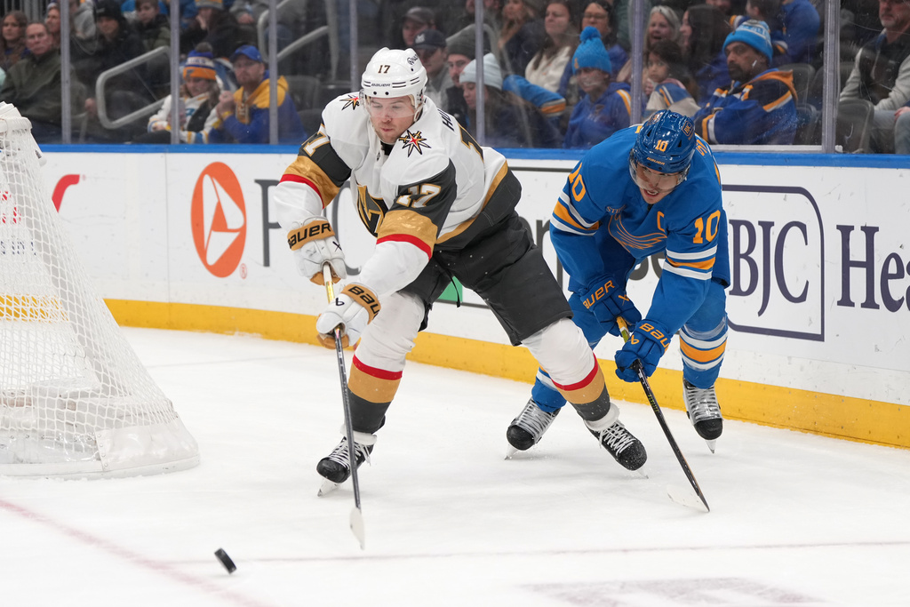 Vegas Golden Knights' Ben Hutton (17) passes as St. Louis Blues' Brayden Schenn (10) watches during the second period of an NHL hockey game Friday, Jan. 2, 2026, in St. Louis. (AP Photo/Jeff Roberson)