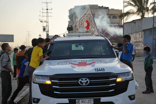 Palestinian kids look into a Red Cross vehicles carrying the bodies of two people believed to be deceased hostages handed over by Hamas make their way toward the Kissufim border crossing with Israel, to be transferred to Israeli authorities, in Deir al-Balah, central Gaza Strip, Thursday, Oct. 30, 2025. (AP Photo/Abdel Kareem Hana) Palestinian kids look into a Red Cross vehicles carrying the bodies of two people believed to be deceased hostages handed over by Hamas make their way toward the Kissufim border crossing with Israel, to be transferred to Israeli authorities, in Deir al-Balah, central Gaza Strip, Thursday, Oct. 30, 2025. (AP Photo/Abdel Kareem Hana)