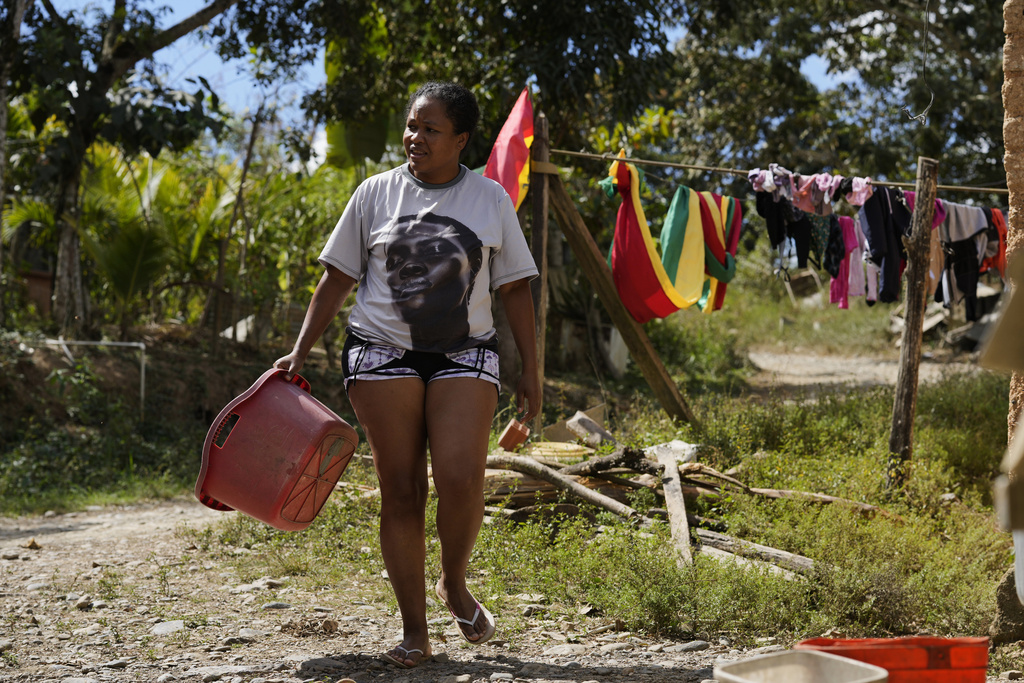 An Afro-Bolivian woman walks away after hanging laundry to dry, near Tocana, in Los Yungas region of Bolivia, Sunday, Aug. 3, 2025. (AP Photo/Juan Karita)