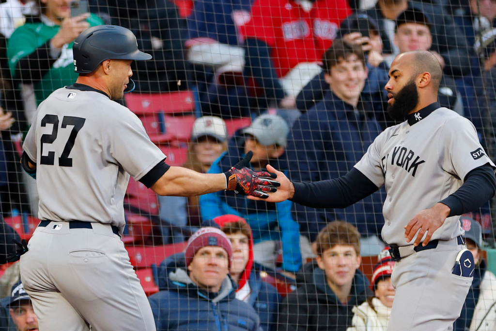 New York Yankees' Giancarlo Stanton, left, is greeted by Amed Rosario, right, after Stanton hit a solo home run during the second inning of a baseball game against the Boston Red Sox on Tuesday, April 21, 2026, in Boston. (AP Photo/CJ Gunther)