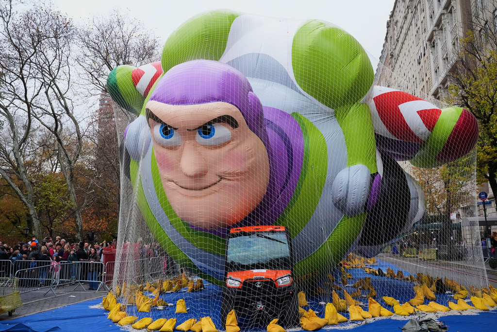 People pass Buzz Lightyear during the balloon inflation for the 99th Macy's Thanksgiving Day Parade, Wednesday, Nov. 26, 2025, in New York. (AP Photo/Frank Franklin II)