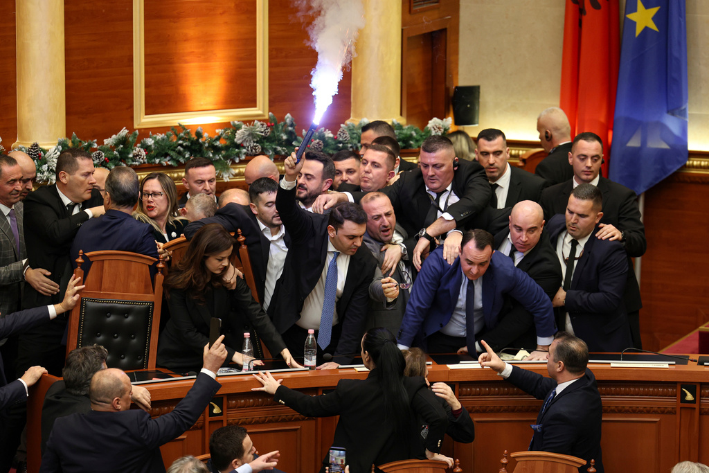 Belind Kellici, a Member of Parliament representing the Democratic Party, holds a flare during tensions between the ruling Socialist Party and the opposition during a parliament session in Tirana, Albania, Thursday, Dec. 18, 2025. (AP Photo)