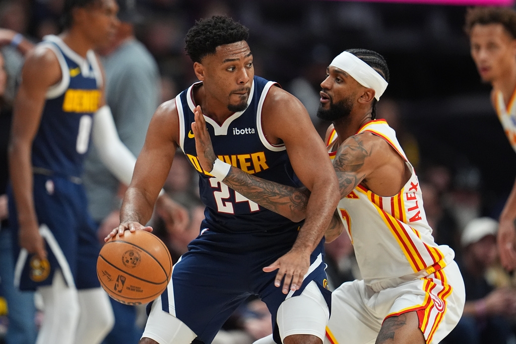 Denver Nuggets guard Jalen Pickett, left, looks to pass the ball as Atlanta Hawks guard Nickeil Alexander-Walker defends in the first half of an NBA basketball game, Friday, Jan. 9, 2026, in Denver. (AP Photo/David Zalubowski)