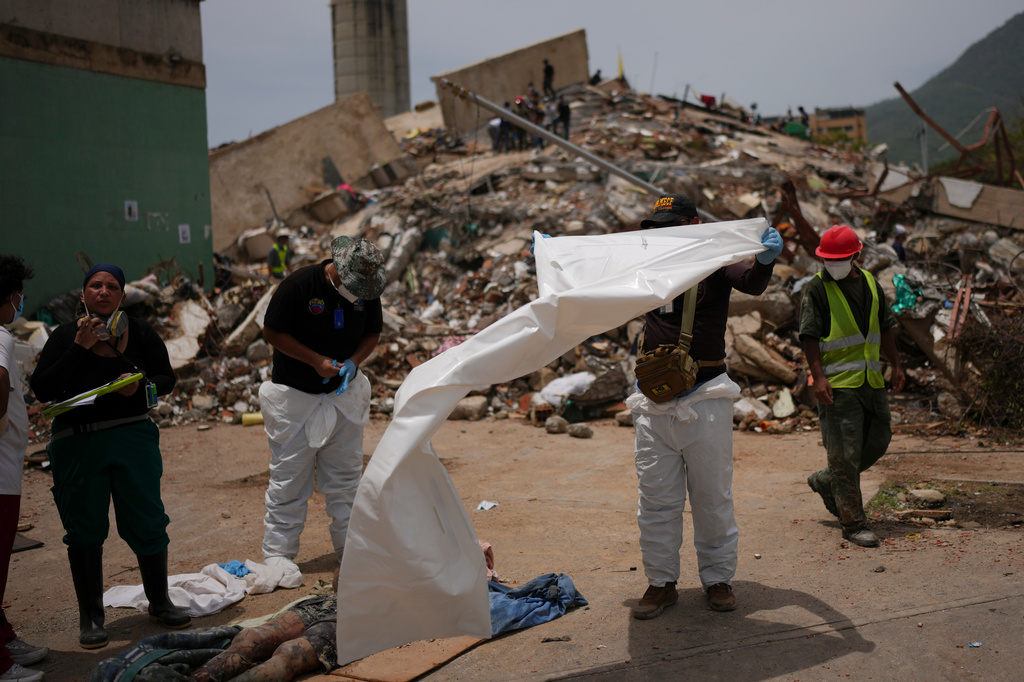 Forensic technicians cover the bodies of earthquake victims in La Guaira, Venezuela, Tuesday, June 30, 2026. (AP Photo/Matias Delacroix)