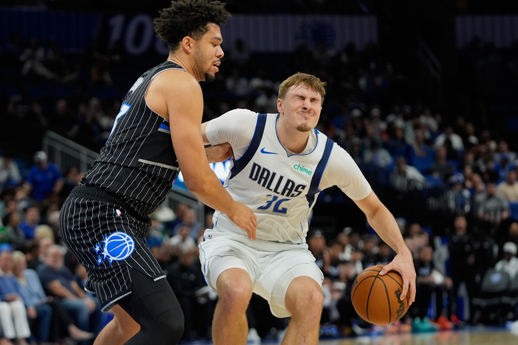 Dallas Mavericks forward Cooper Flagg (32) grimaces as he collides with Orlando Magic forward Noah Penda, left, during the first half of an NBA basketball game, Thursday, March 5, 2026, in Orlando, Fla. (AP Photo/John Raoux)