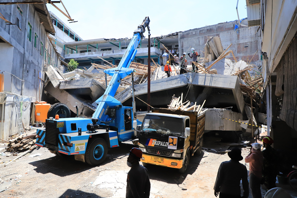 Rescuers deploy a crane to clear the rubble at the site where a building under construction collapsed Monday at an Islamic boarding school in Sidoarjo, East Java, Indonesia, Thursday, Oct. 2, 2025. (AP Photo/Trisnadi)