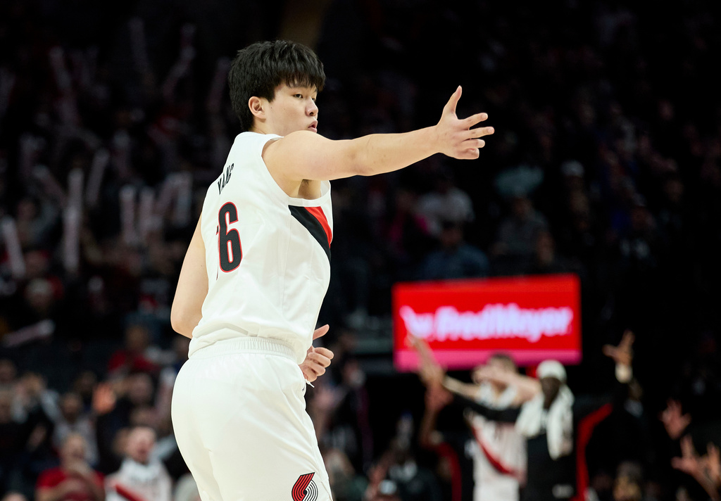 Portland Trail Blazers center Yang Hansen reacts after making a three-point basket against the Houston Rockets during the first half of an NBA basketball game in Portland, Ore., Wednesday, Jan. 7, 2026. (AP Photo/Craig Mitchelldyer)