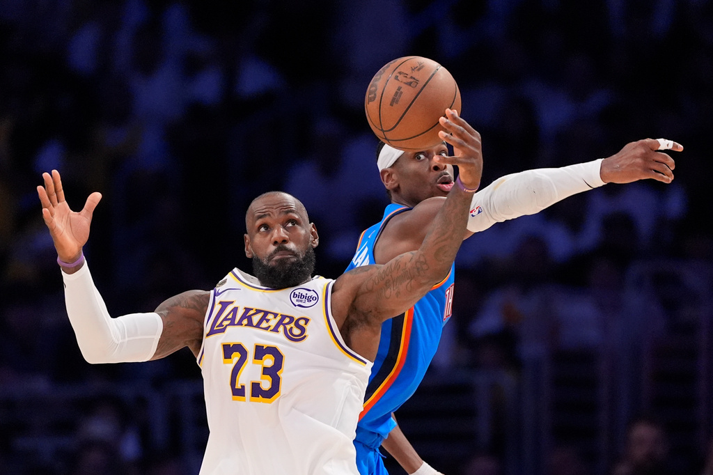 FILE - Los Angeles Lakers forward LeBron James, left, takes a pass as Oklahoma City Thunder guard Shai Gilgeous-Alexander defends during the first half of Game 3 in a second-round NBA basketball playoffs series May 9, 2026, in Los Angeles. (AP Photo/Mark J. Terrill, File)