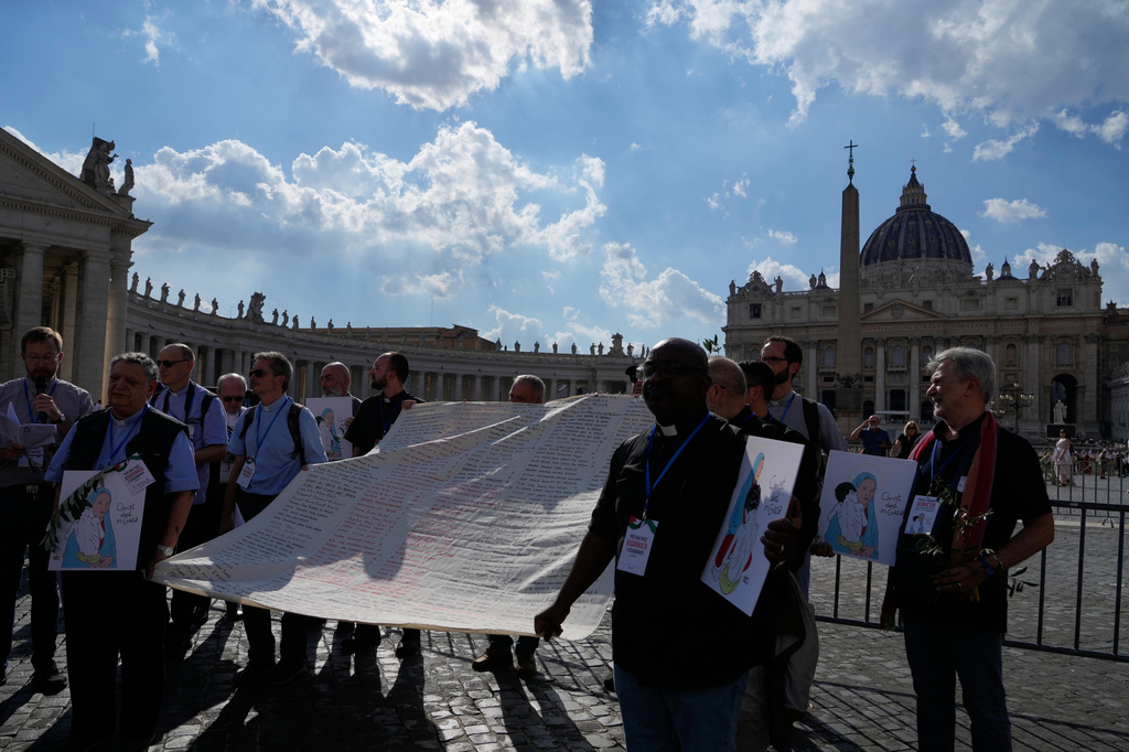 Priests from various countries, members of the "Priests Against Genocide" network, carry a shroud bearing the names of 300 Palestinian and Lebanese children whom organizers say were killed by the Israeli military after ceasefires were declared, during a demonstration near St. Peter's Square at the Vatican, Tuesday, Sept. 22, 2026. (AP Photo/Gregorio Borgia)