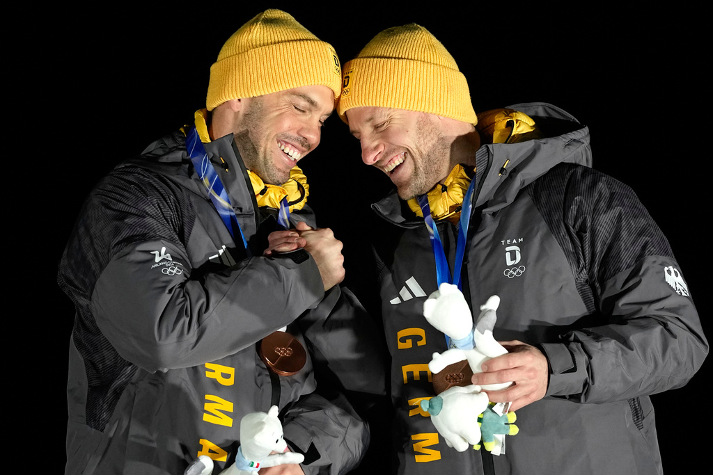 Germany's bronze medalists Tobias Wendl, left, Tobias Arlt, right, celebrate after men's doubles luge competitions at the 2026 Winter Olympics, in Cortina d'Ampezzo, Italy, Wednesday, Feb. 11, 2026. (AP Photo/Alessandra Tarantino)