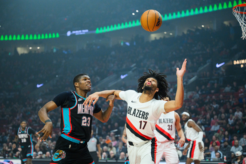 Memphis Grizzlies guard Cedric Coward (23) and Portland Trail Blazers guard Shaedon Sharpe (17) compete for the ball in the first half of an NBA basketball game Friday, Feb. 6, 2026, in Portland, Ore. (AP Photo/Molly J. Smith)