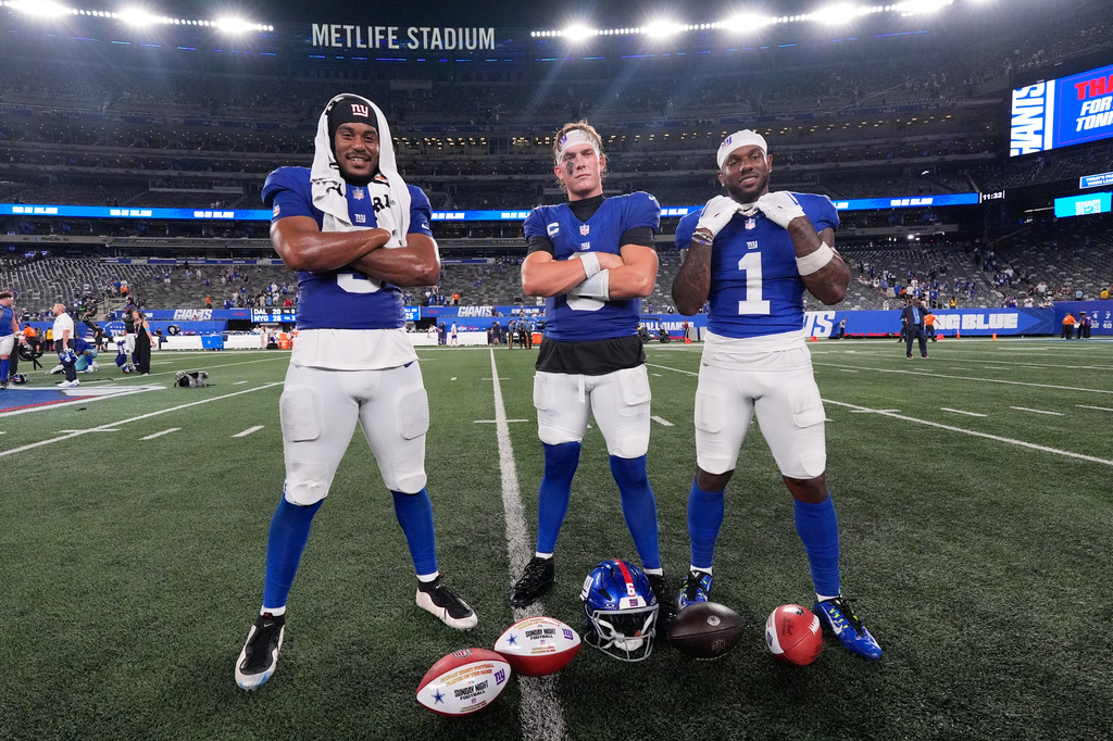 New York Giants players, from left, Isaiah Likely, Jaxson Dart and Malik Nabers pose for photographs following an NFL football game against the Dallas Cowboys Sunday, Sept. 13, 2026, in East Rutherford, N.J. (AP Photo/Yuki Iwamura)