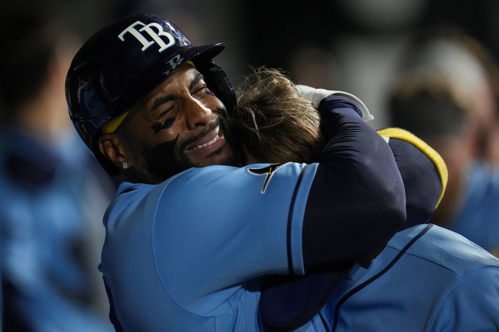 Tampa Bay Rays designated hitter Yandy Diaz (2), left, hugs Jonny DeLuca (21) after DeLuca hit a three-run home run during the seventh inning of a baseball game against the Chicago White Sox, Wednesday, April 15, 2026, in Chicago. (AP Photo/Erin Hooley)
