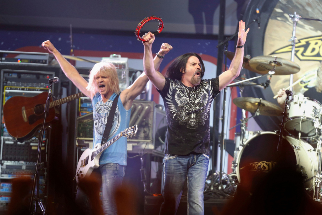 FILE - Tommy DeCarlo, lead singer of the group Boston, right, performs at the Boston Strong Concert: An Evening of Support and Celebration at the TD Garden, Thursday, May 30, 2013, in Boston. (Photo by Bizuayehu Tesfaye/Invision/AP, File)
