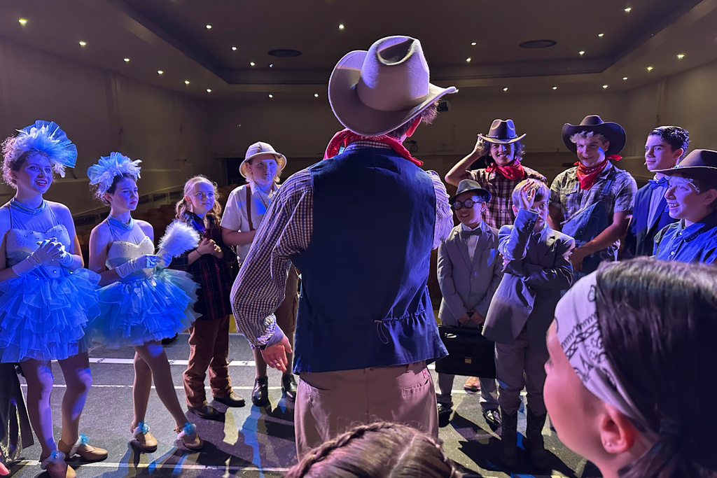 FILE - Callum Ganz, 17, center, gives a pre-show pep talk to castmates in Crazy for You on opening night as the Theatre Palisades Youth group returns to the stage after losing their theater in the Palisades fire, in Los Angeles, Feb. 28, 2025. (AP Photo/Jocelyn Gecker, File)