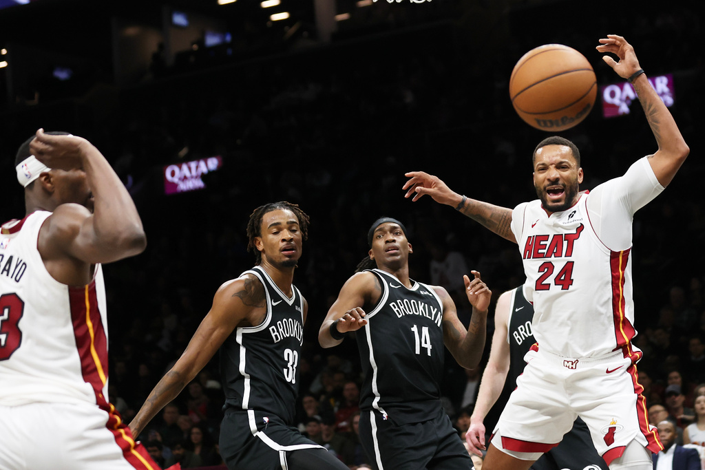 Miami Heat guard Norman Powell (24) loses the ball against Brooklyn Nets defenders during the first half of an NBA basketball game, Thursday, Dec. 18, 2025, in New York. (AP Photo/Heather Khalifa)