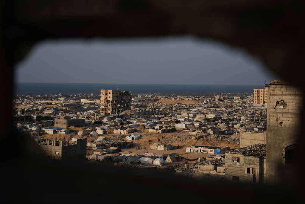 A tent camp for displaced Palestinians stretches amid the ruins of destroyed buildings in Khan Younis, in the southern Gaza Strip, Saturday, Nov. 8, 2025. (AP Photo/Abdel Kareem Hana)