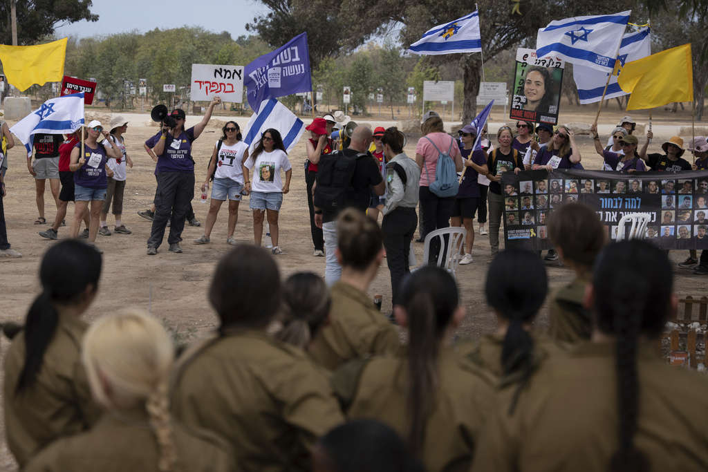 Relatives and supporters of hostages held by Hamas in the Gaza Strip take part in a protest calling for their release as they stand at the site where revelers were killed on Oct. 7, 2023, at the Nova music festival, near the Kibbutz Reim, southern Israel, Thursday, Aug. 28, 2025. (AP Photo/Maya Levin)