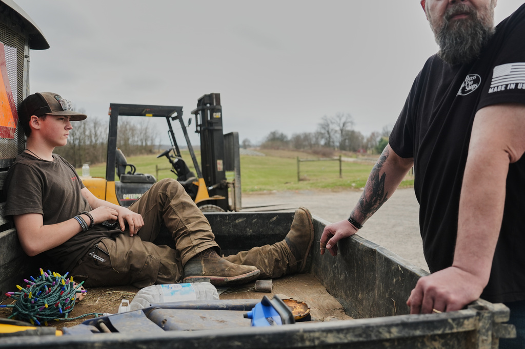 Blake Greier, 13, left, relaxes in the back of a farm vehicle Tuesday, March 10, 2026, in Canfield, Ohio. (AP Photo/Joshua A. Bickel)