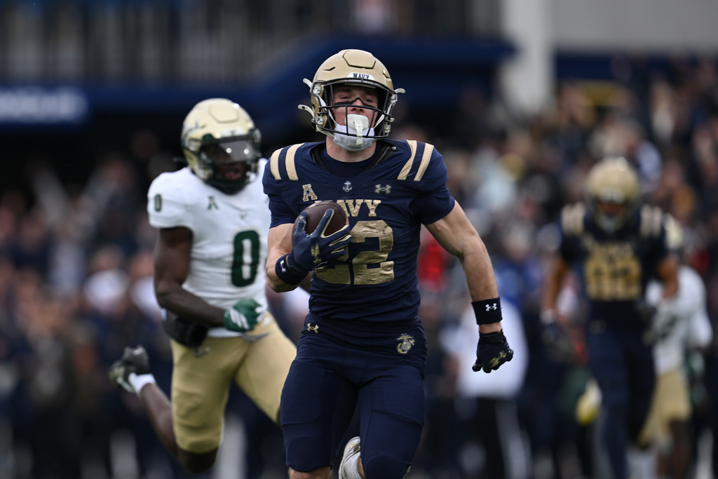 Navy running back Charles Robinson (23) catches a pass and runs for a first down during the first half of a NCAA college football game against South Florida, Saturday, Nov. 15, 2025, in Annapolis, Md.(AP Photo/Gail Burton)