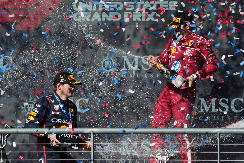 Race winner Red Bull driver Max Verstappen of the Netherlands, left, celebrates on the podium with third placed Ferrari driver Charles Leclerc of Monaco after the Formula One U.S. Grand Prix auto race in Austin, Texas, Sunday, Oct. 19, 2025. (AP Photo/Eric Gay)