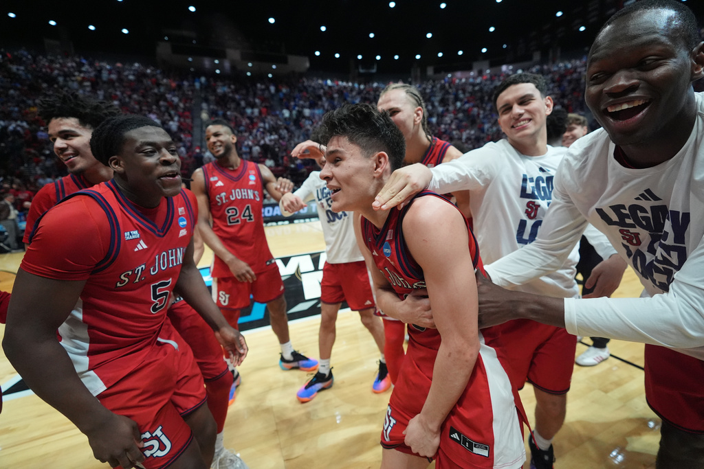 St. John's guard Dylan Darling (0) celebrates with teammates after defeating Kansas a game in the second round of the NCAA college basketball tournament Sunday, March 22, 2026, in San Diego. (AP Photo/Marcio Jose Sanchez)