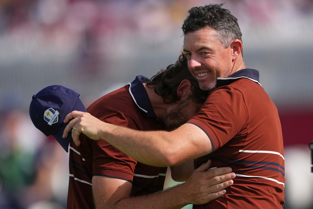 Europe's Rory McIlroy and Tommy Fleetwood hug after they won their match at Bethpage Black golf course during the Ryder Cup golf tournament, Saturday, Sept. 27, 2025, in Farmingdale, N.Y. (AP Photo/Lindsey Wasson)