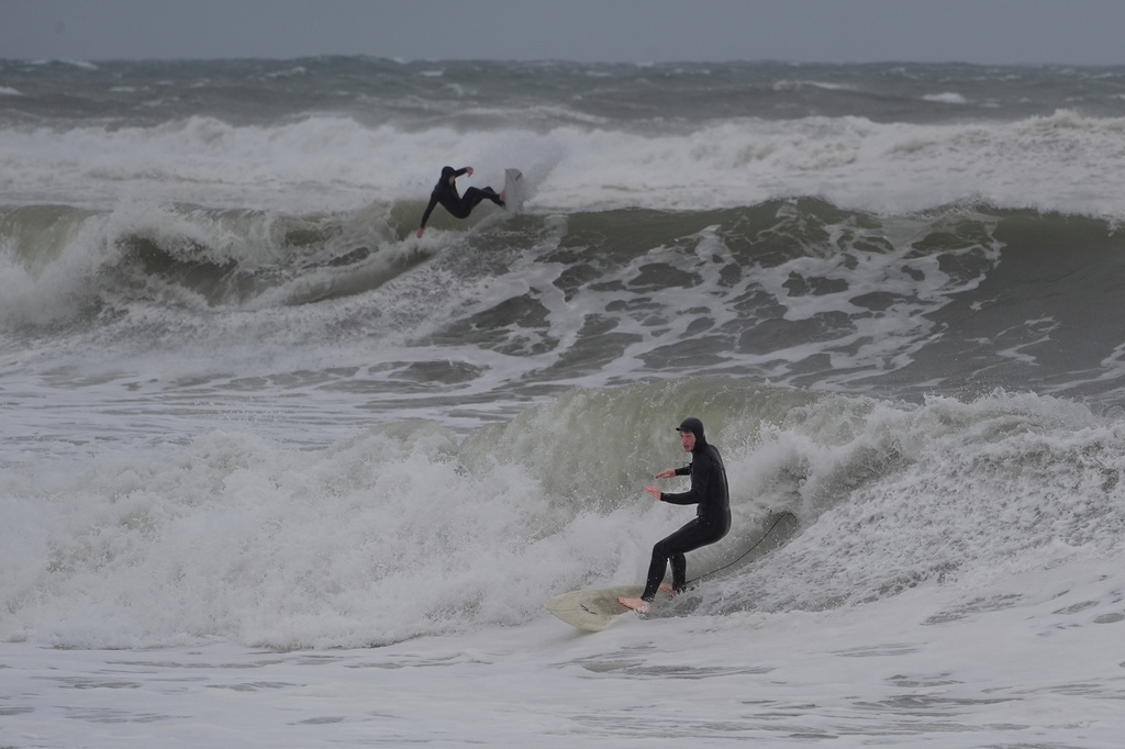 Surfers ride waves kicked up by a nor'easter storm, Saturday, Sept. 26, 2026, in Hampton, N.H. (AP Photo/Robert F. Bukaty)