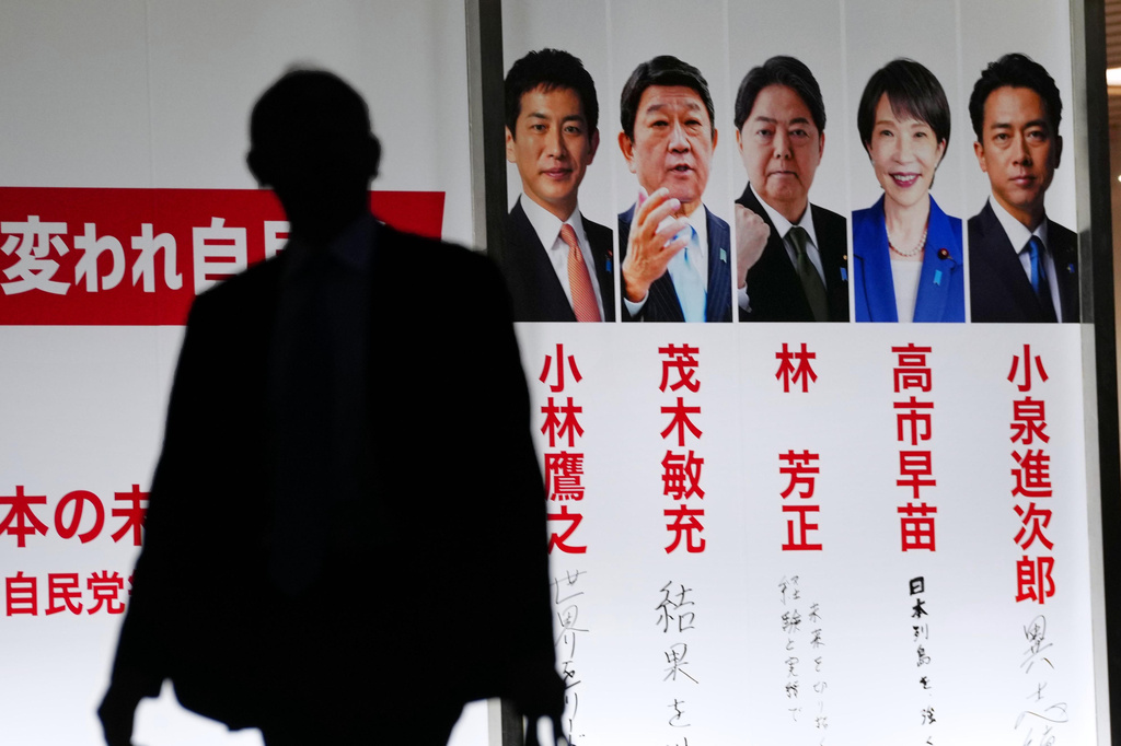 Photos of the candidates running for the ruling Liberal Democratic Party's leader are displayed at the party's headquarters in Tokyo on Oct. 3, 2025. From left are former Economic Security Minister Takayuki Kobayashi, former Secretary-General Toshimitsu Motegi, Chief Cabinet Secretary Yoshimasa Hayashi, former Economic Security Minister Sanae Takaichi and Agriculture Minister Shinjiro Koizumi. (Yohei Fukai/Kyodo News via AP)