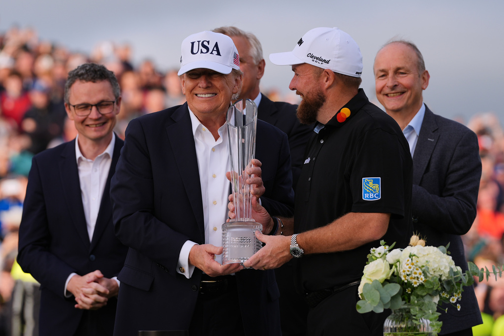 U.S. President Donald Trump, center left, presents the trophy to Shane Lowry of Ireland during the Irish Open golf tournament at Trump International Golf Links in Doonbeg, Ireland, Sunday, Sept. 13, 2026. (AP Photo/Julia Demaree Nikhinson)