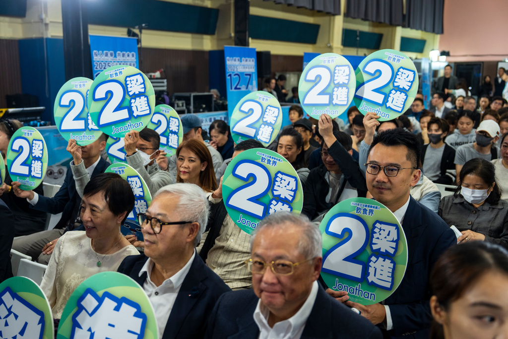 Supporters of Jonathan Leung, candidate of the Legislative Council Catering functional constituency election, hold placard at a forum in Hong Kong on Wednesday, Dec. 3, 2025. (AP Photo/Chan Long Hei)